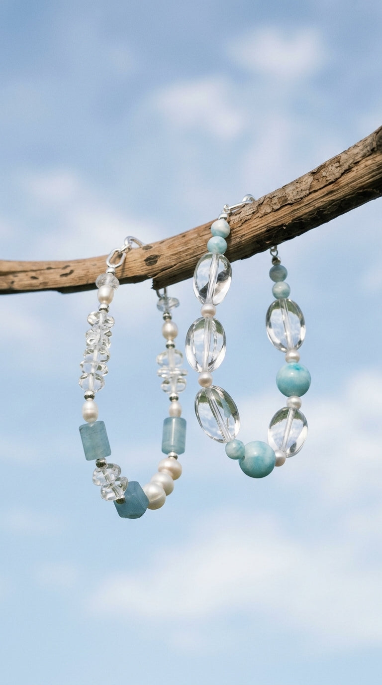 Two blue stone and crystal bracelets suspended from a branch